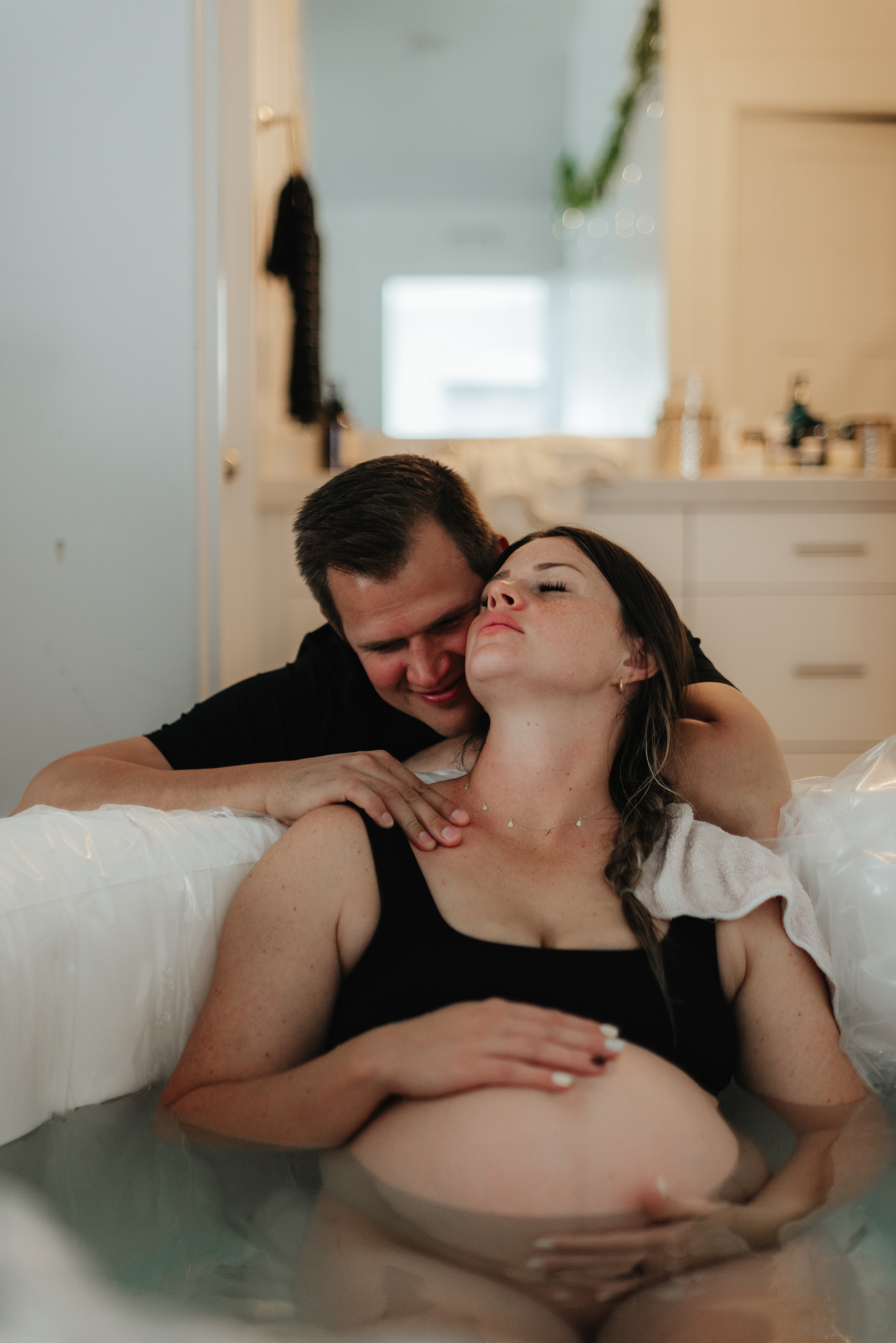 parent supported by their partner during a water birth