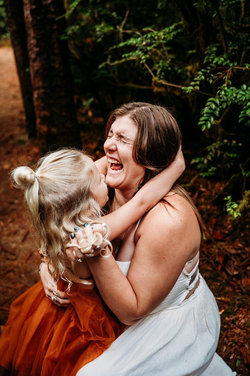 mother laughing with her daughter, embraced in a joyful hug