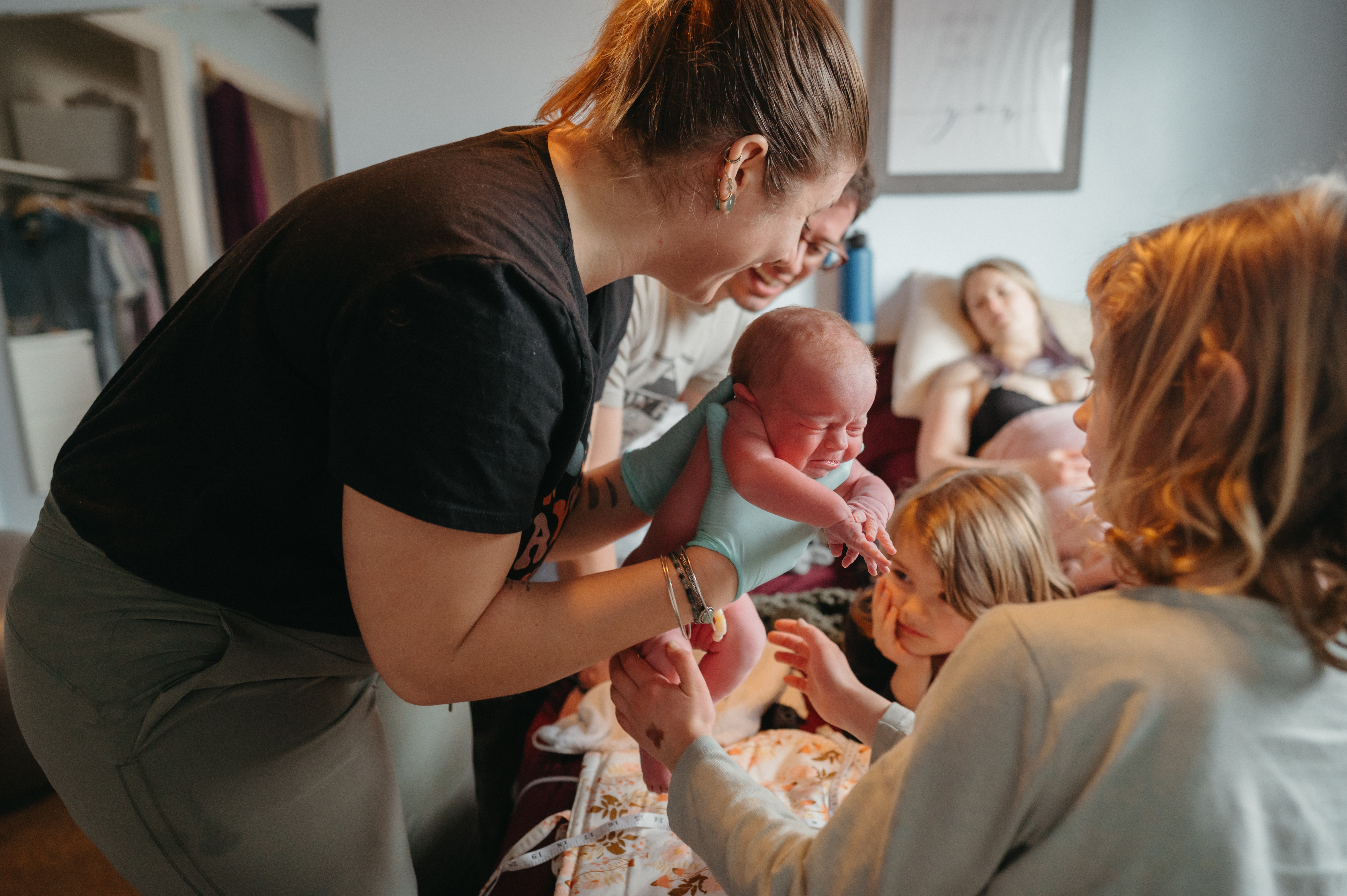 doula reviewing postpartum care instructions with a family at home