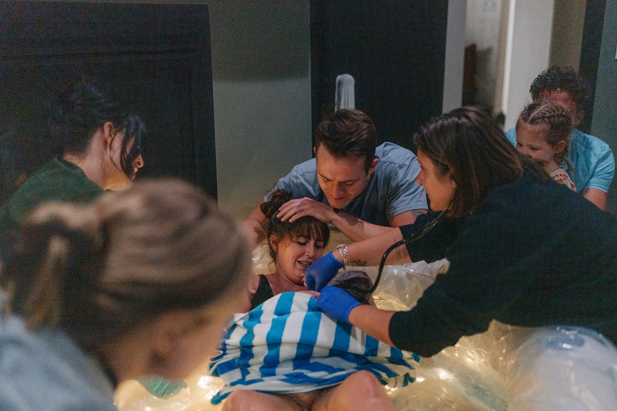 midwife gently caring for a newborn moments after birth